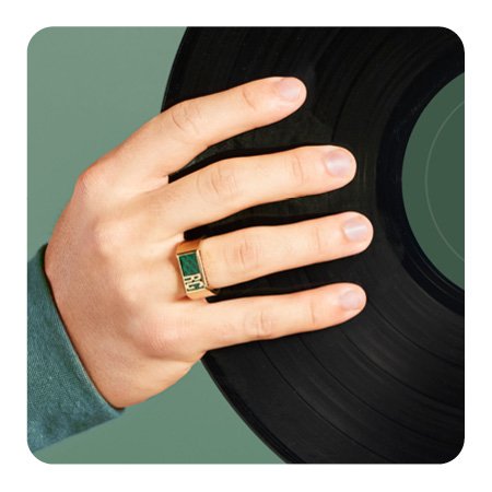 A person wearing a class ring holding a record.