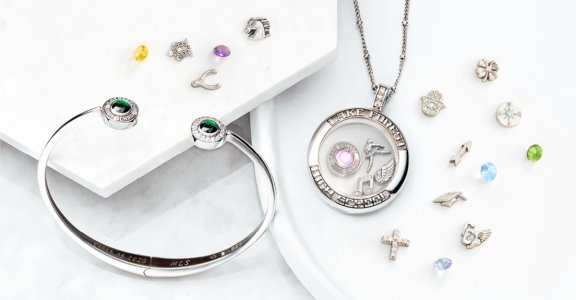 A class bracelet laying next to a class necklace.