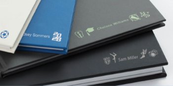 Yearbooks laying on top of each other with personalized icons.